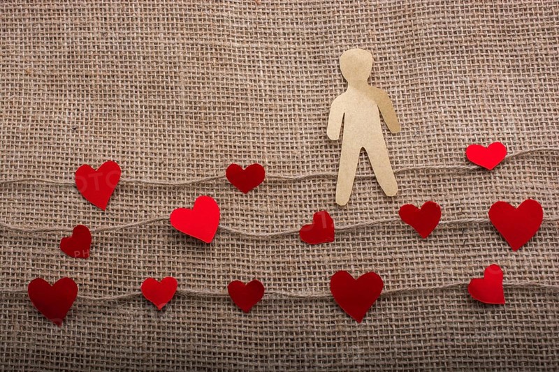 Paper man and heart icons on linen threads on canvas