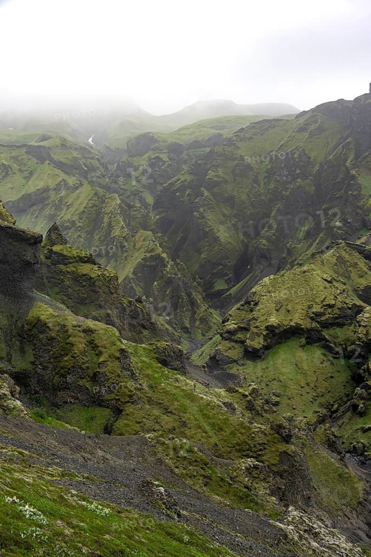 View into rugged moss-covered canyon with tufa rock formations