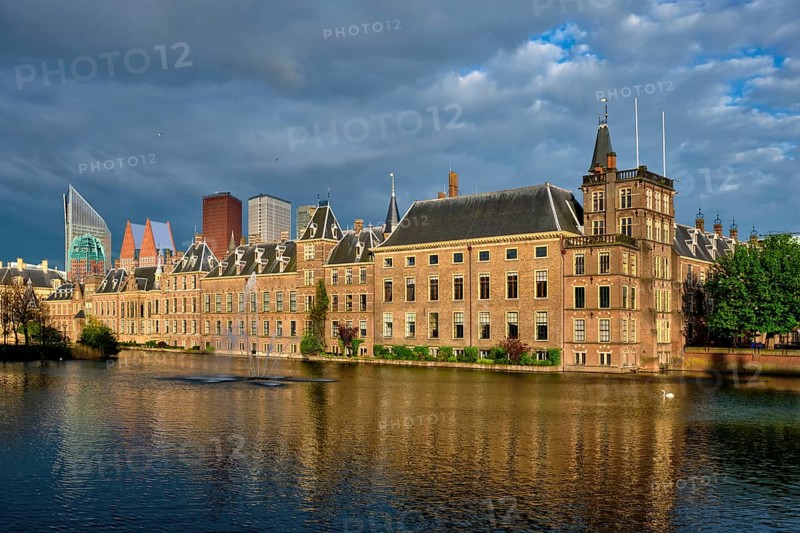 View of the Binnenhof House of Parliament and the Hofvijver lake with downtown skyscrapers in background