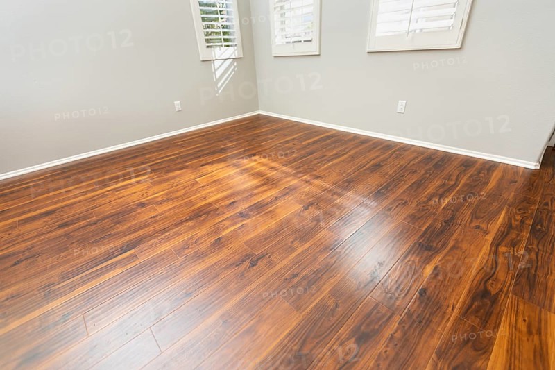 Newly installed brown laminate flooring and baseboards in home