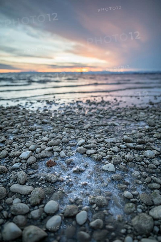 Sunrise on a wintry lake in bad weather