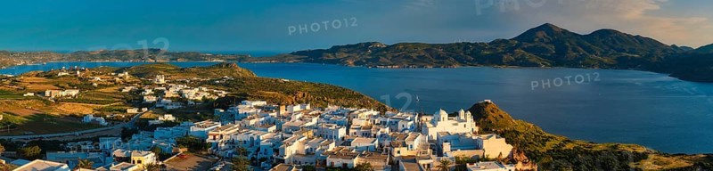 Panorama of Plaka village on Milos island with traditional greek white houses on sunset