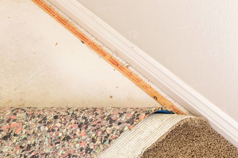 Pulled back carpet and padding in room of house