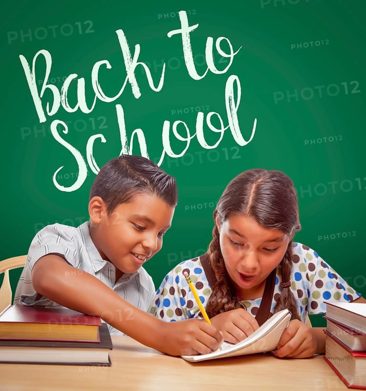 Back to school written on chalk board behind hispanic boy and girl having fun studying together