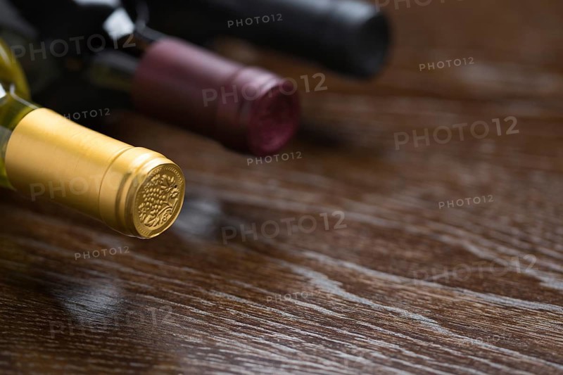 Various wine bottles on a reflective wood surface abstract