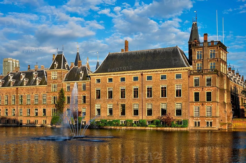 View of the Binnenhof House of Parliament and the Hofvijver lake with downtown skyscrapers in background. The Hague