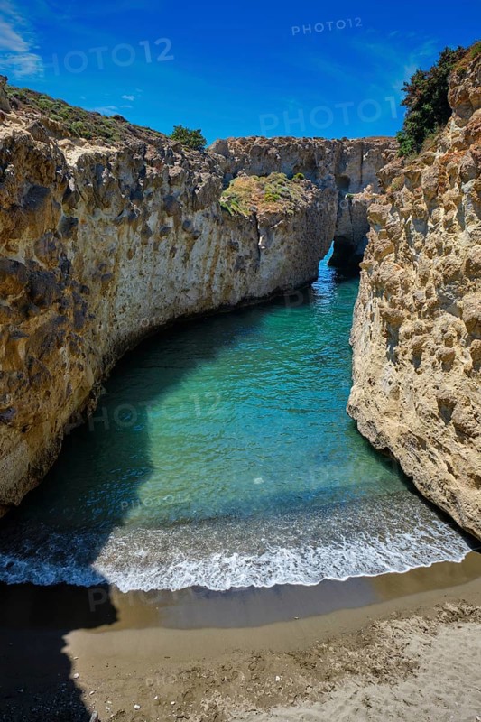 Papafragas hidden beach with crystal clear turquoise water and tunnel rock formations in Milos island