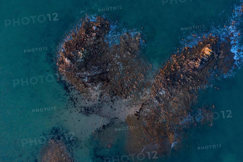 Aerial view of rock formations in the sea in front of the sandy beach Ker Emma shortly in front of sunset
