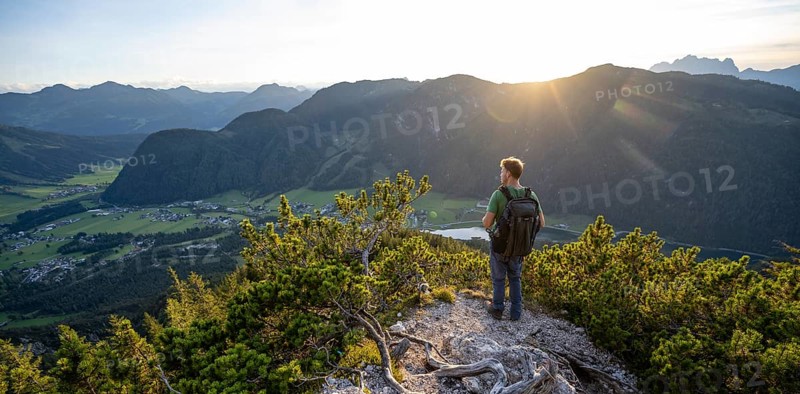 Hiker standing on hiking path between mountain pines