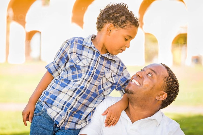 Happy african american father and mixed-race son playing at the park