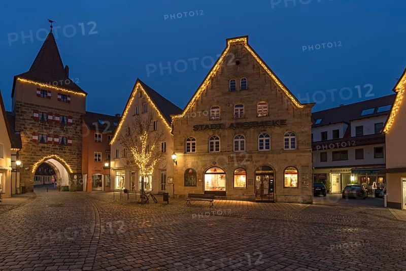 Historic gabled houses and the Hersbruck Gate with Christmas lighting on the market square in the evening