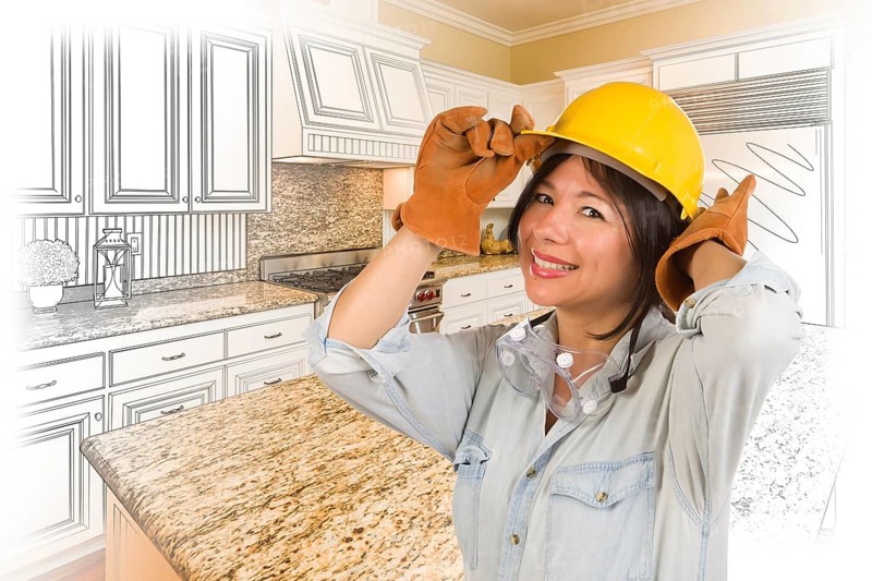 Pretty hispanic woman in hard hat and gloves with kitchen drawing and photo gradation behind
