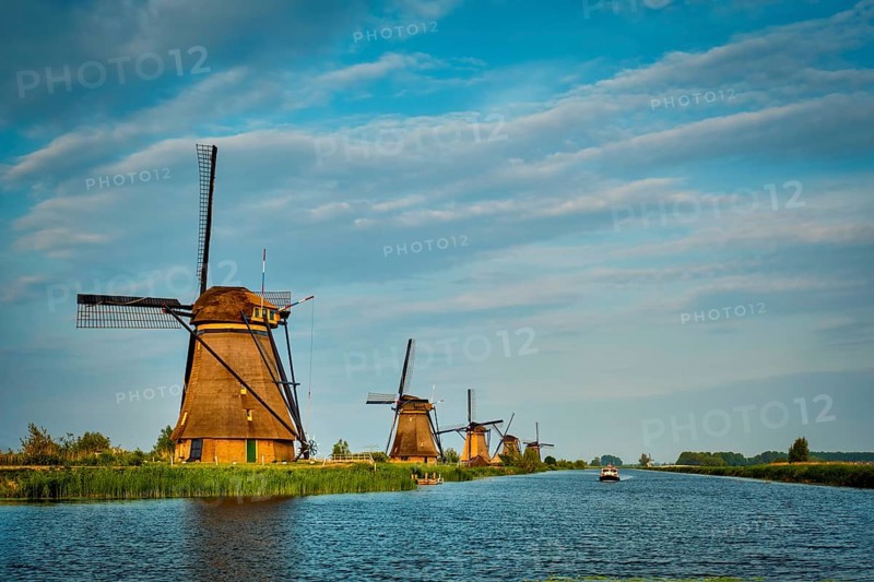 Netherlands rural lanscape with windmills at famous tourist site Kinderdijk in Holland on sunset with dramatic sky