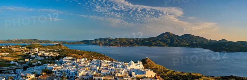 Panorama of Plaka village on Milos island with traditional greek white houses on sunset