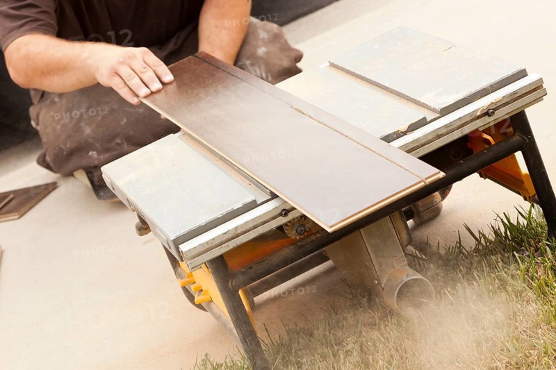 Contractor using circular saw cutting of new laminate flooring renovation