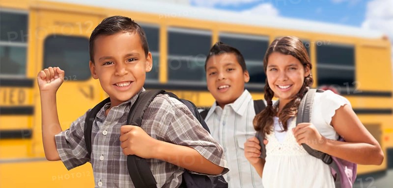 Young hispanic boys and girl walking near school bus