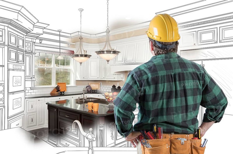 Male contractor with hard hat and tool belt looking at custom kitchen drawing photo combination on white