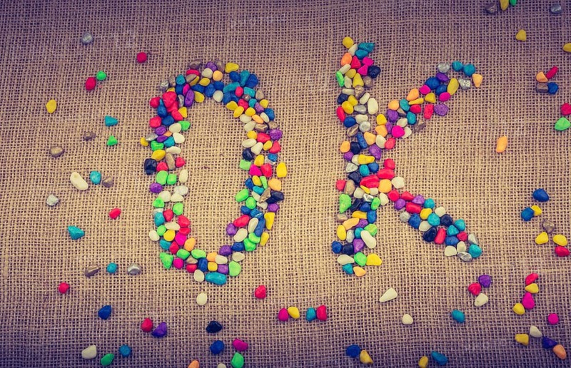 Colorful pebbles form the word OK on canvas ground