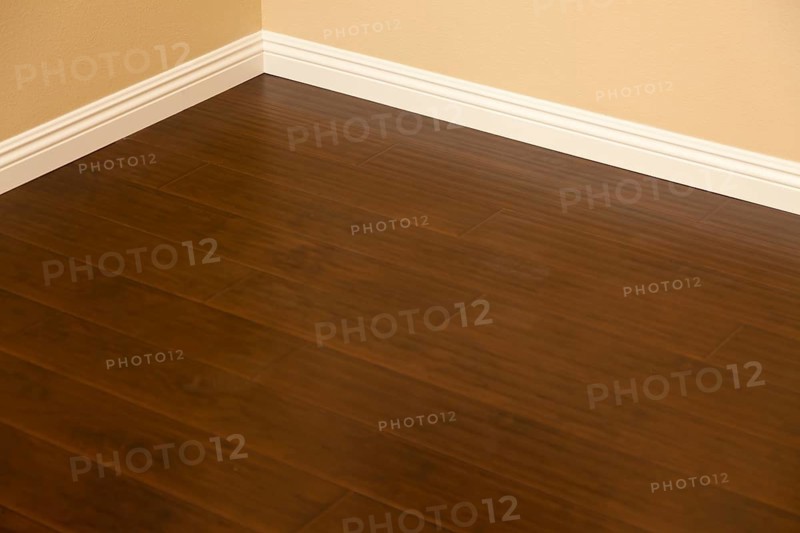 Beautiful newly installed brown laminate flooring and baseboards in home