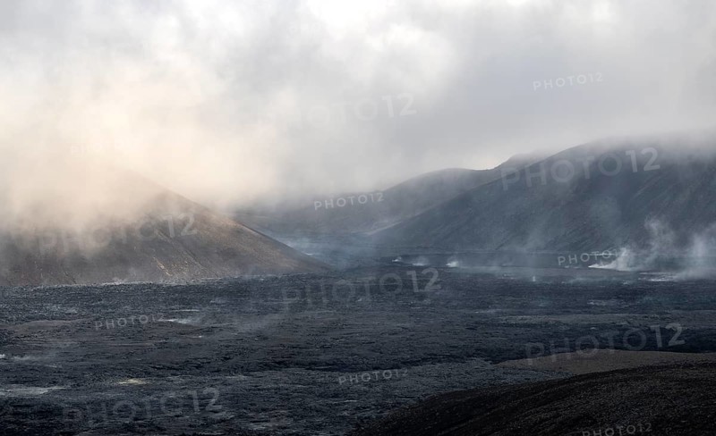 Steaming lava fields between hills