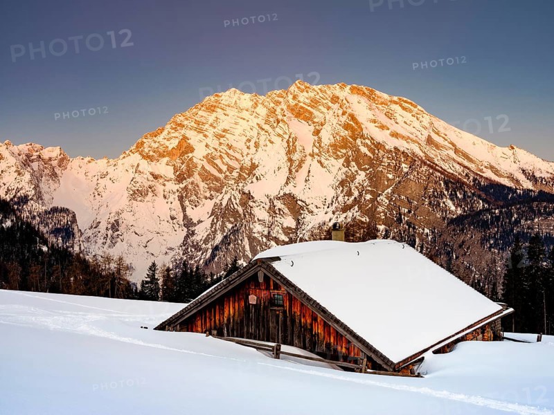 Snowy Priesbergalm in front of Watzmann east face at sunrise