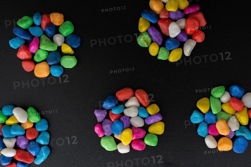 Pile of little colorful pebbles on black background