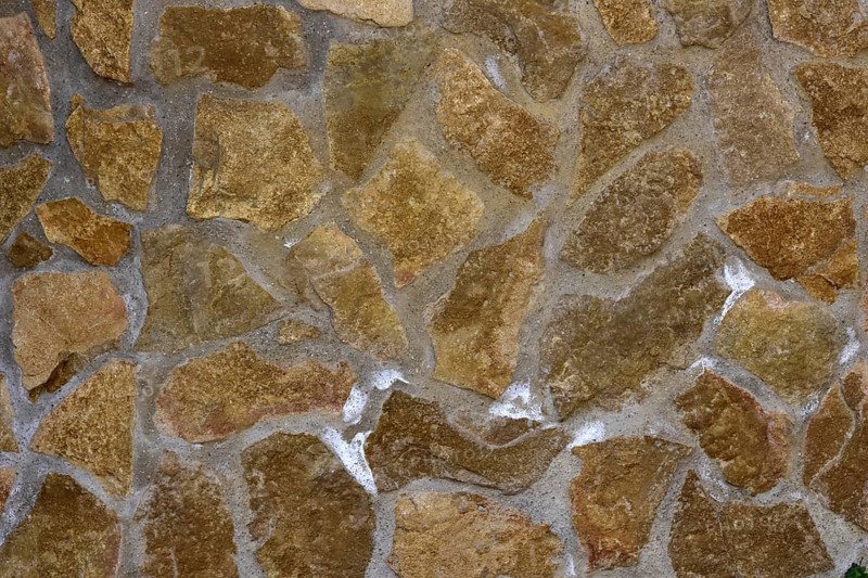 Damp natural stone wall with efflorescent saltpetre Salt
