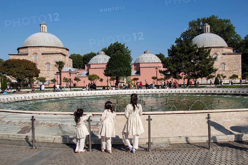 Three little girls by the pool with domes in Istanbul