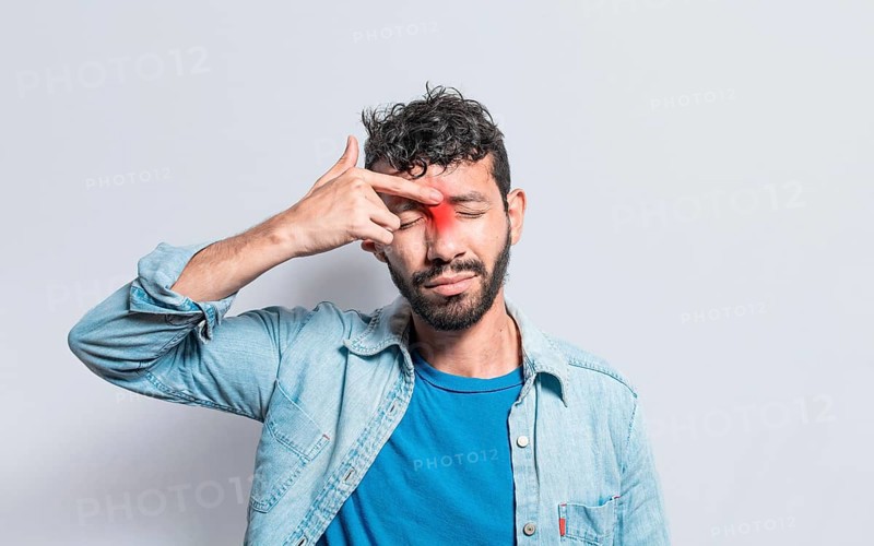 Young man with pain touching nose. A person with nasal bridge pain
