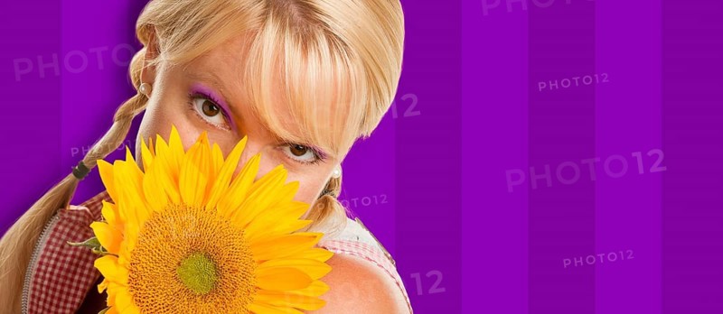 Beautiful girl holding yellow sunflower against purple striped background