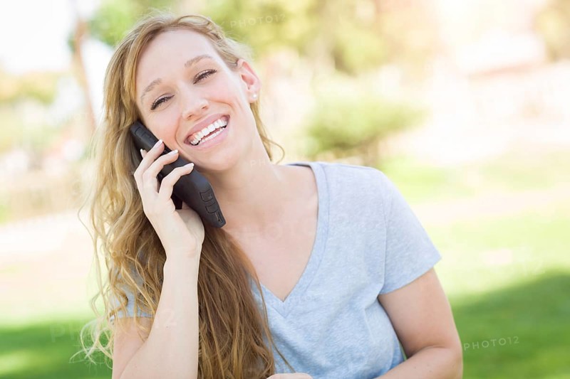 Young adult woman outdoors talking on her smart phone