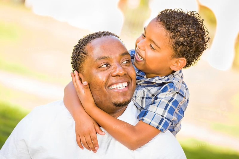 Happy african american father and mixed-race son playing at the park