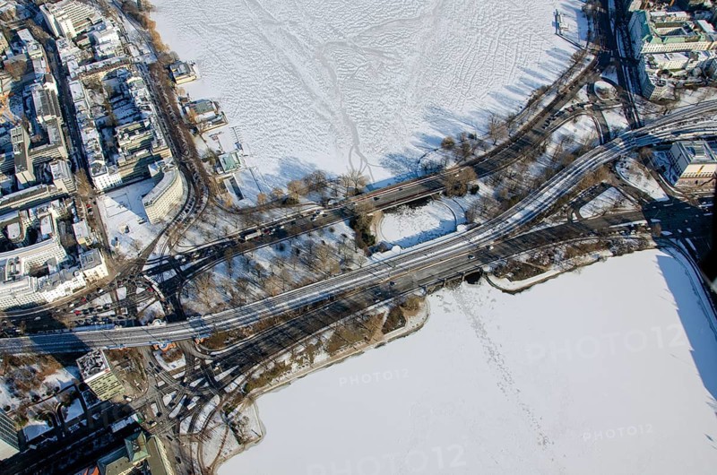 Road and railway bridge over the Alster in winter with ice and snow