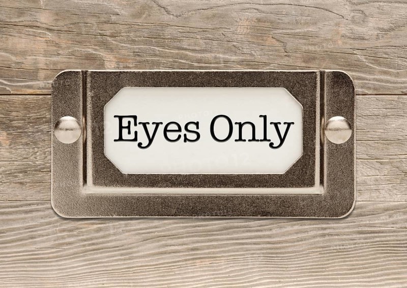 Eyes only metal file label frame on wood background