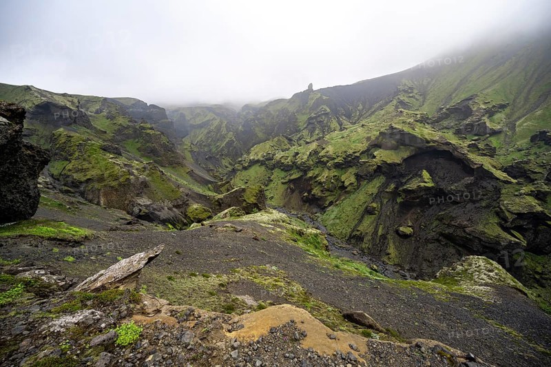 View into rugged moss-covered canyon with tufa rock formations