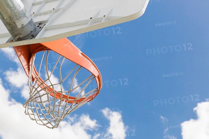 Abstract of community basketball hoop and net against blue sky