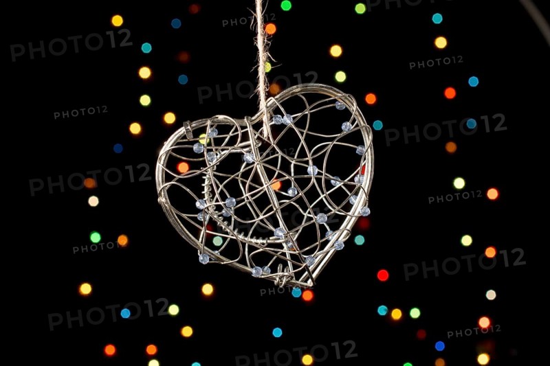 Heart shaped metal cage on a bokeh light background