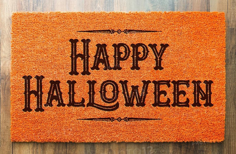 Happy halloween orange welcome mat on wood floor background