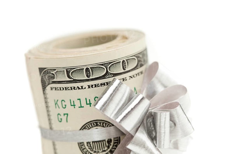 Roll of one hundred dollar bills with silver bow on white
