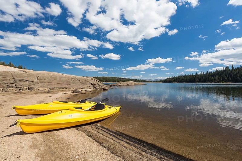 Pair of yellow kayaks on a beautiful mountain lake shore