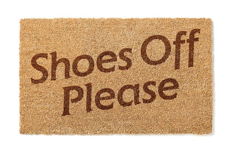 Shoes off welcome mat isolated on A white background