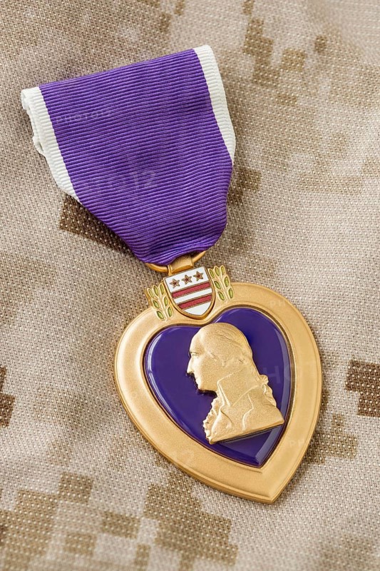 Purple heart medal laying on military fatigues