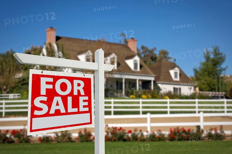 Home for sale real estate sign in front of new house