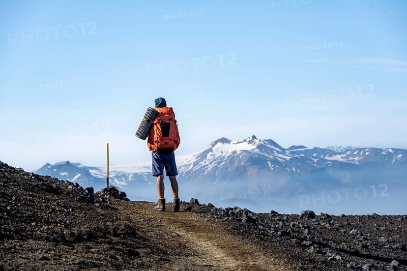 Hikers on trail through volcanic landscape