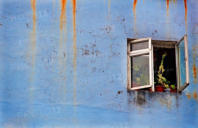 Verwitterte Fassade mit geoeffneten Fenster