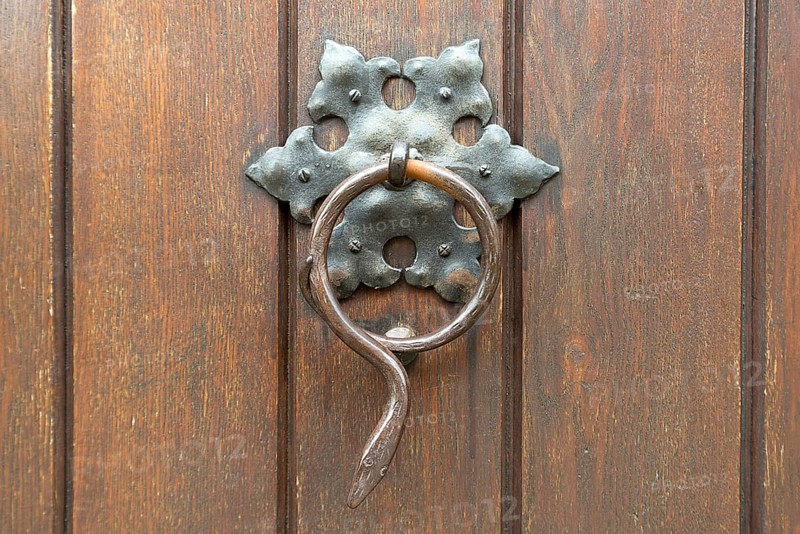 Snake figure as a door knocker on the door of a parish
