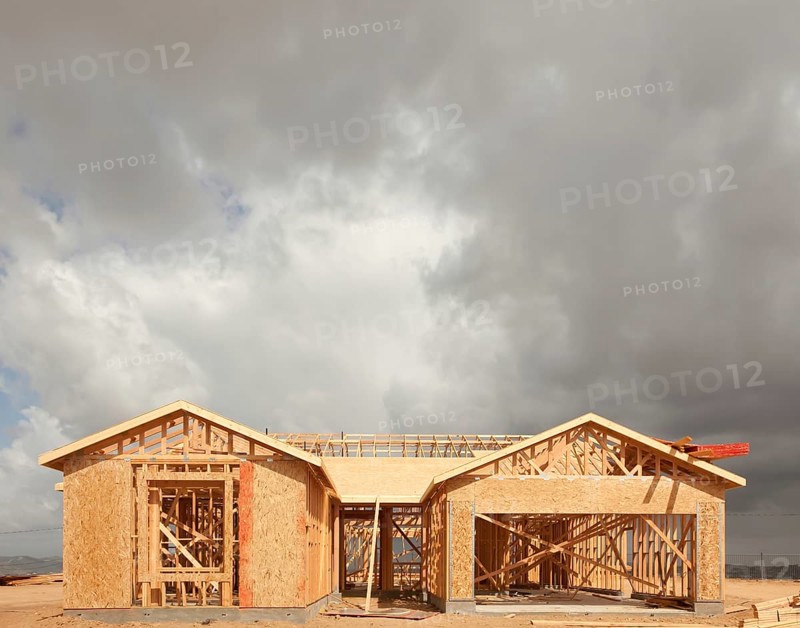 Wood home framing abstract at construction site with stormy clouds behind