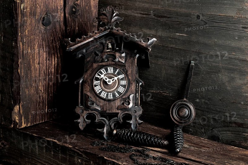 Antique Black Forest cuckoo clock on wooden background