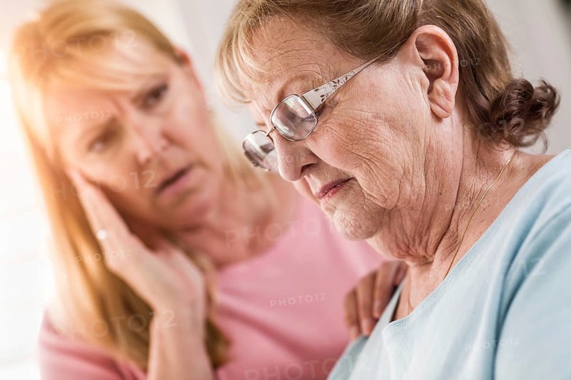 Young adult woman consoles sad senior adult female