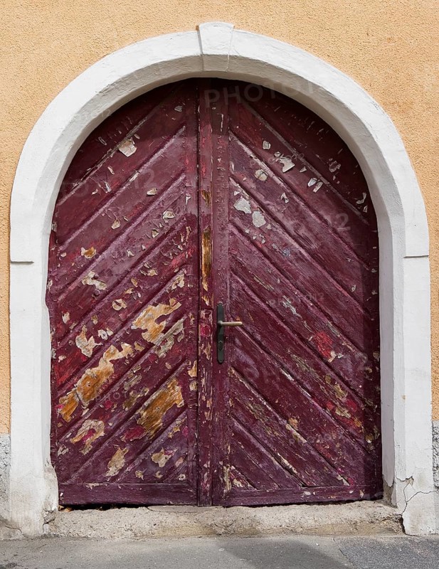 Hausfassade mit alter verwitterter Haustuer mit Rundbogen